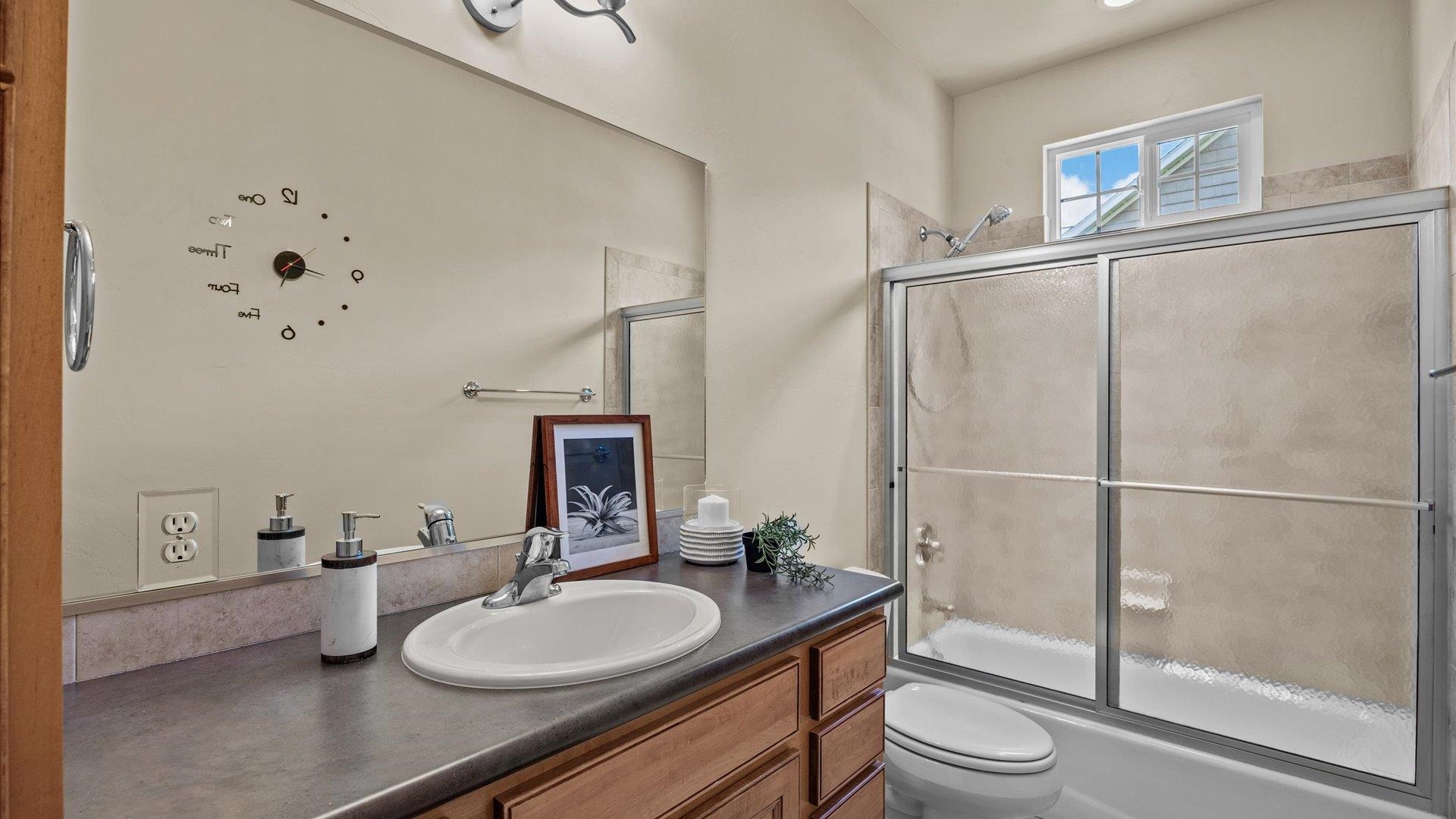 1115 Sunrose Lane Fruita, CO 81521 - Photo 20 of 32 a bathroom with a granite countertop sink toilet a mirror and shower