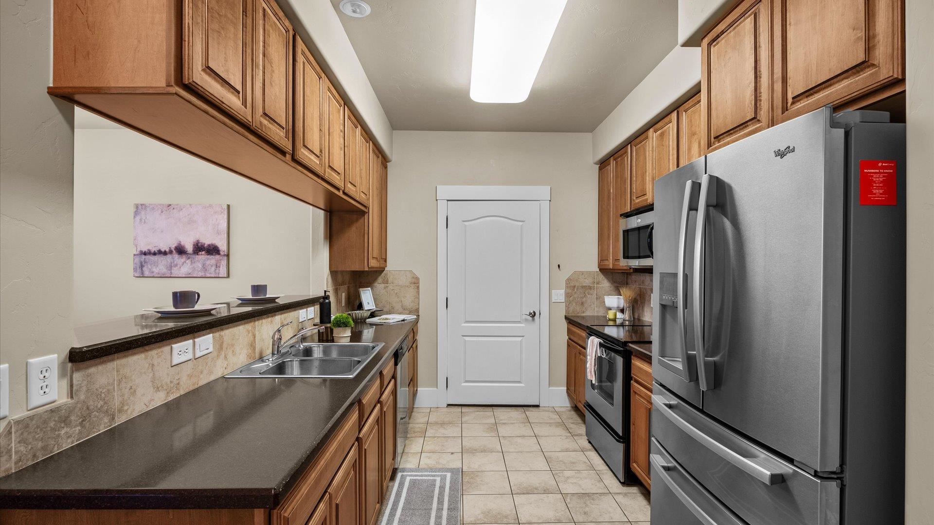 1115 Sunrose Lane Fruita, CO 81521 - Photo 7 of 32 a kitchen with stainless steel appliances granite countertop a refrigerator a stove and a sink