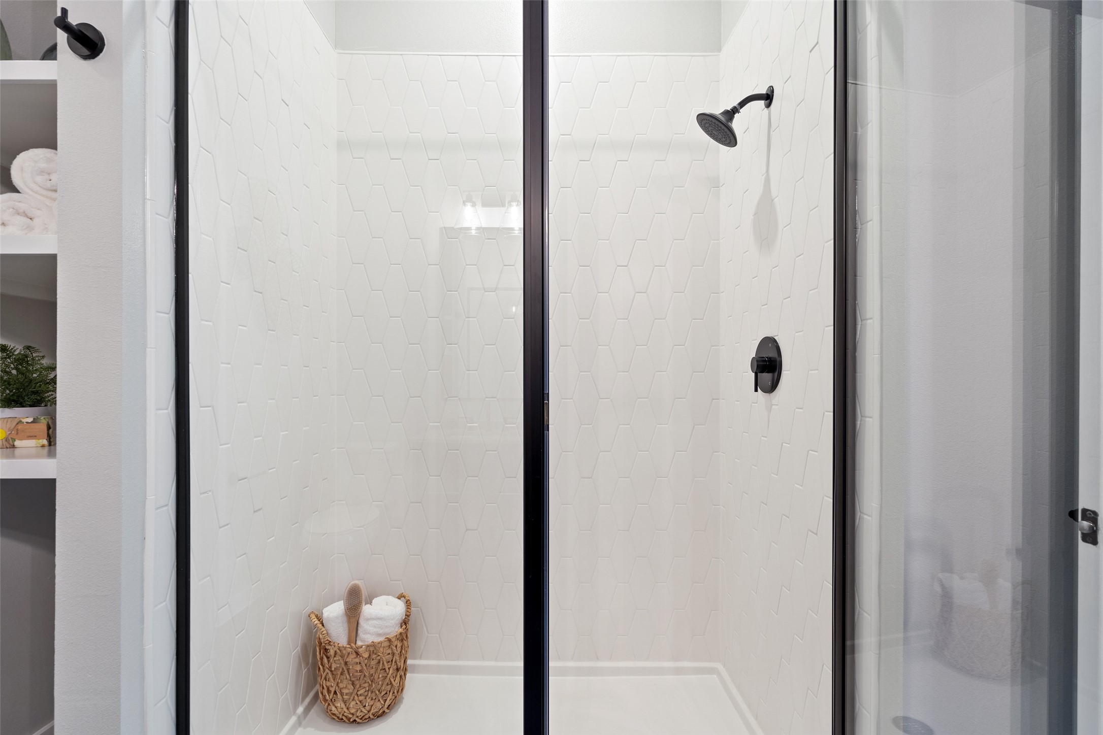 4510 Terry-O Lane, Unit 341 Austin, TX 78745 - Photo 31 of 40 The shower features a clear glass enclosure with a black frame, white hexagonal wall tiles, and matte black shower fixtures