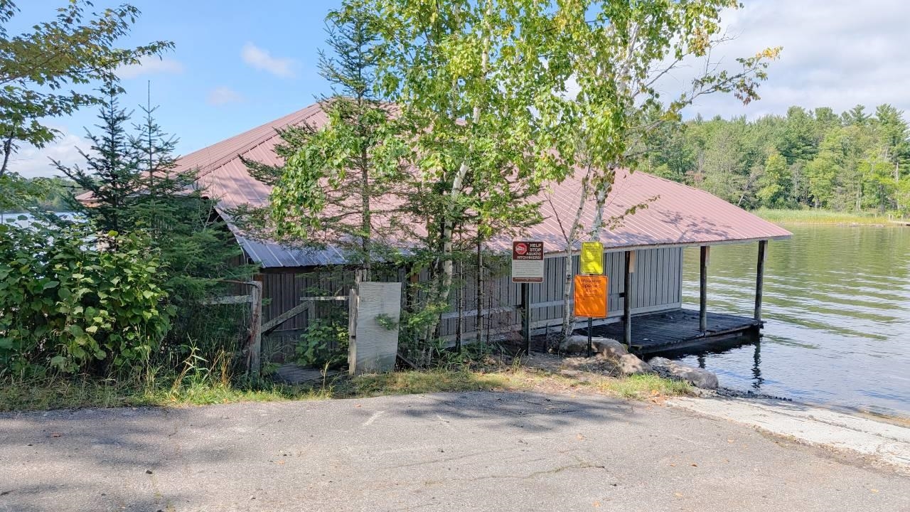 8159 Ludlow Road Cook, MN 55723 - Photo 24 of 32 View of front of property featuring a metal roof, a boat dock, and a water view