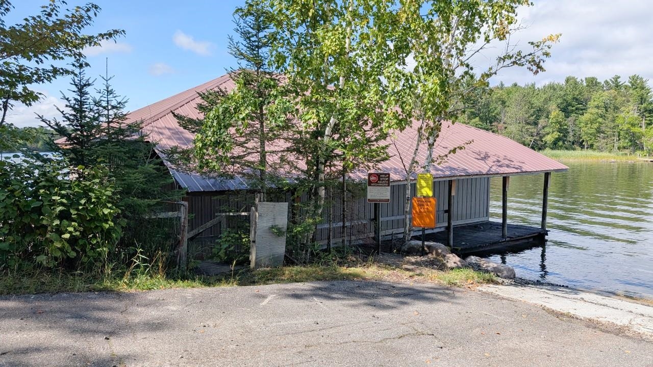 8159 Ludlow Road Cook, MN 55723 - Photo 25 of 32 View of front of property featuring a metal roof, a boat dock, and a water view