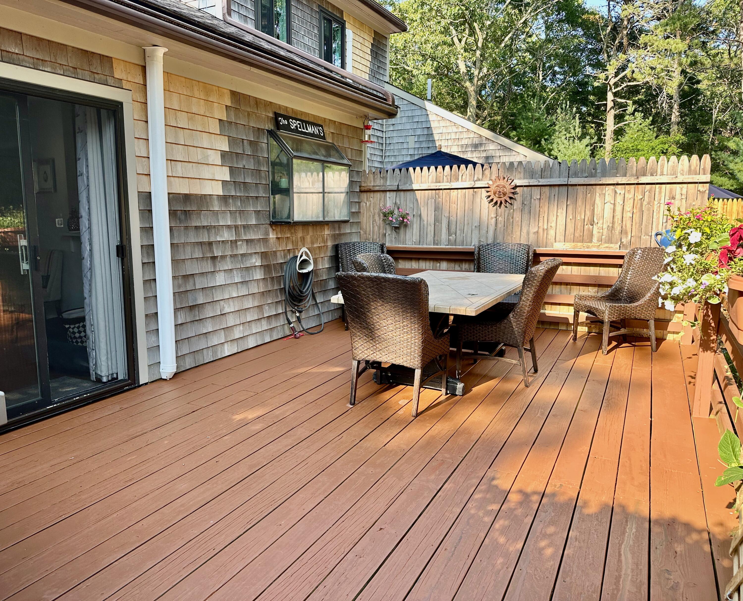 21 Round House Road Bourne, MA 02532 - Photo 16 of 21 a view of a patio with table and chairs with wooden floor and fence