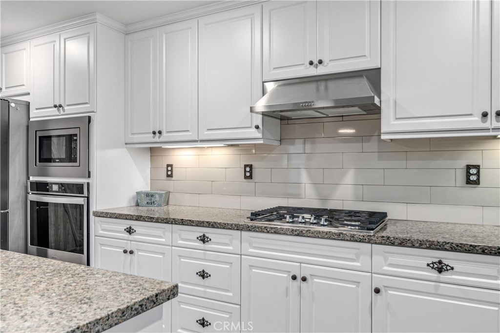 44451 63rd Street West Lancaster, CA 93536 - Photo 15 of 47 a kitchen with granite countertop white cabinets and stainless steel appliances