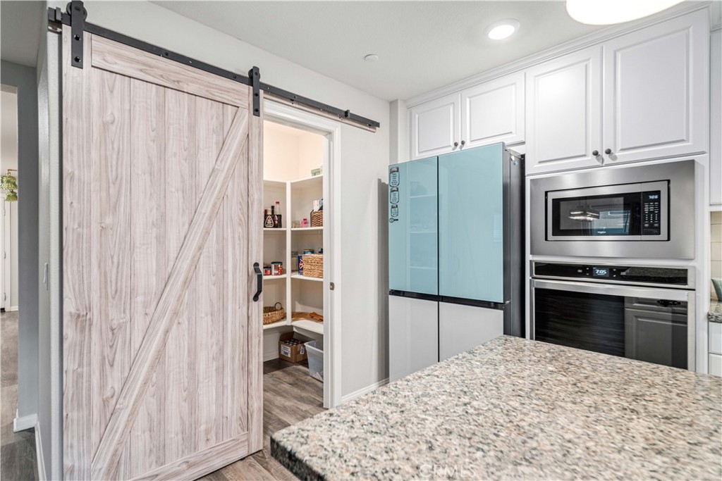 44451 63rd Street West Lancaster, CA 93536 - Photo 16 of 47 a kitchen with granite countertop a refrigerator and a stove top oven