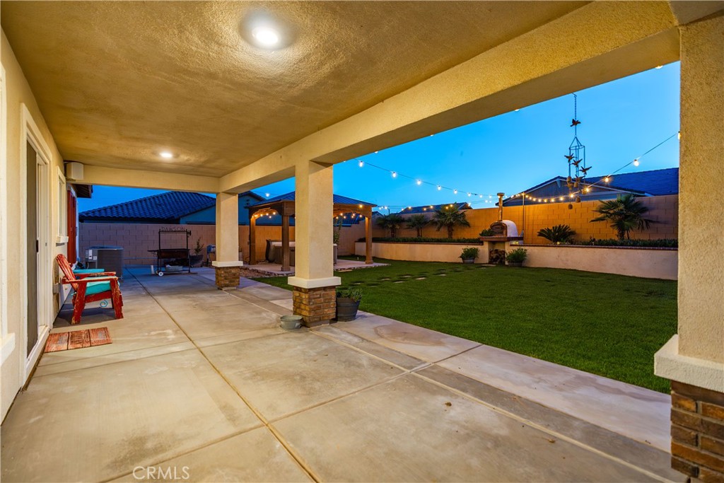 44451 63rd Street West Lancaster, CA 93536 - Photo 27 of 47 a view of a patio with a table and chairs under an umbrella