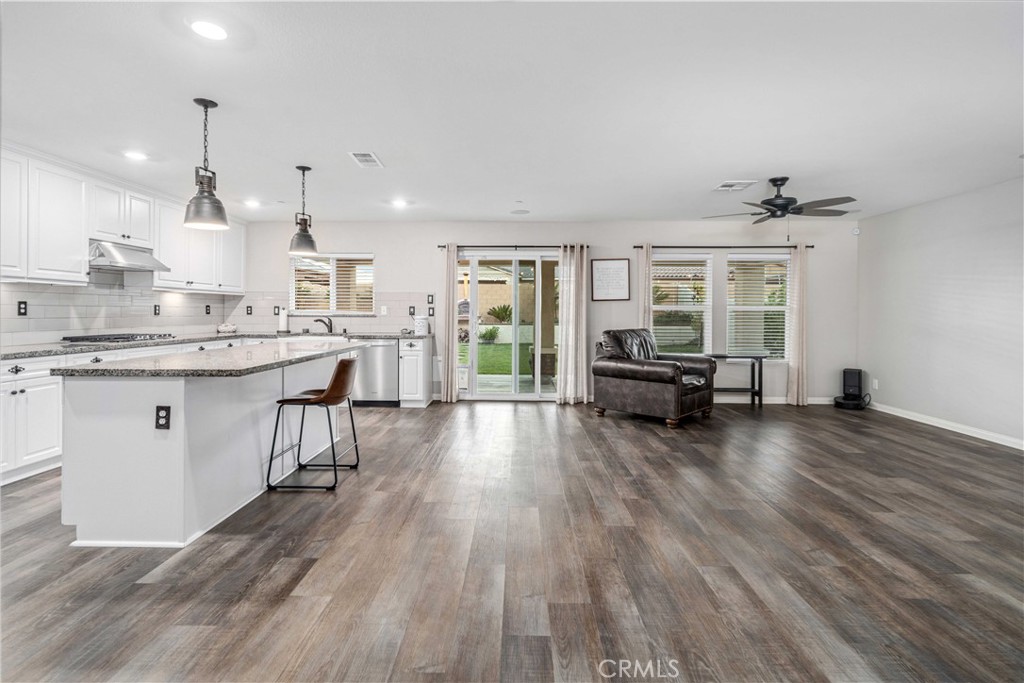 44451 63rd Street West Lancaster, CA 93536 - Photo 8 of 47 a kitchen with stainless steel appliances granite countertop a sink dishwasher a stove and a dining table with wooden floor