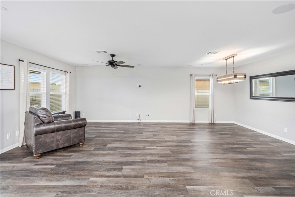 44451 63rd Street West Lancaster, CA 93536 - Photo 10 of 47 a view of a livingroom with hardwood floor and a ceiling fan