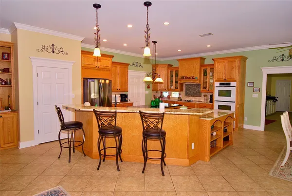 a large kitchen with stainless steel appliances granite countertop a stove a sink and a dining table