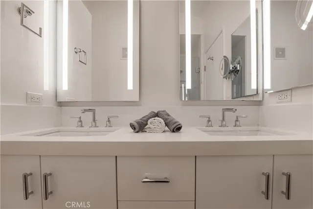 a bathroom with double sink and a mirror