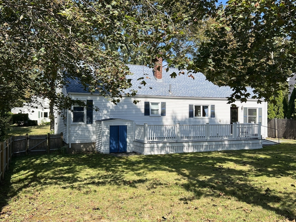 48 Ashton Street Beverly, MA 01915 - Photo 4 of 24 a front view of a house with a yard tree and a wooden fence