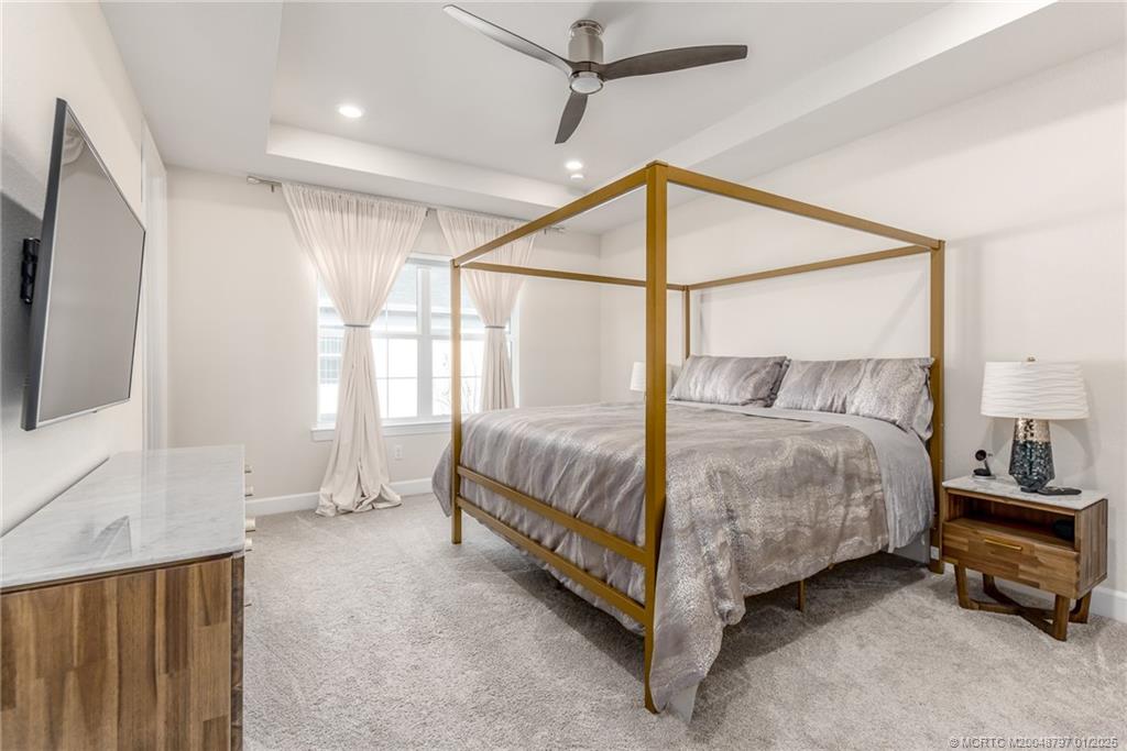 1865 Southeast Tarni Way Stuart, FL 34996 - Photo 11 of 23 a bedroom with a bed and a flat tv screen on the dresser