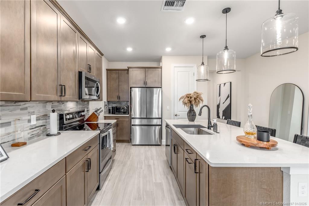 1865 Southeast Tarni Way Stuart, FL 34996 - Photo 6 of 23 a kitchen that has a lot of cabinets and refrigerator