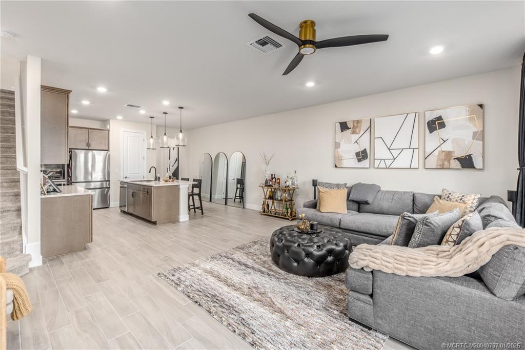 1865 Southeast Tarni Way Stuart, FL 34996 - Photo 7 of 23 a spacious bedroom with a bed a couch and a view of kitchen