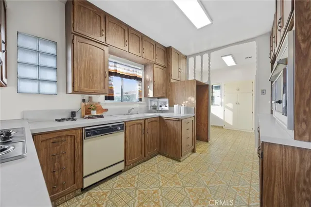 a kitchen with a sink cabinets appliances and a window