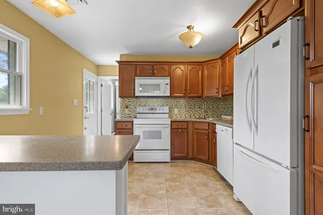 a kitchen with stainless steel appliances granite countertop a refrigerator sink and cabinets