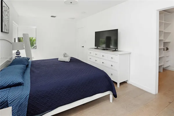 a bedroom with a bed and a flat screen tv