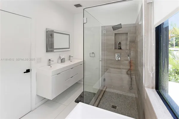 a bathroom with a shower sink and mirror