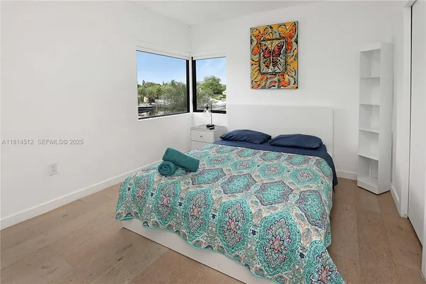 a bedroom with a bed and painting on the wall