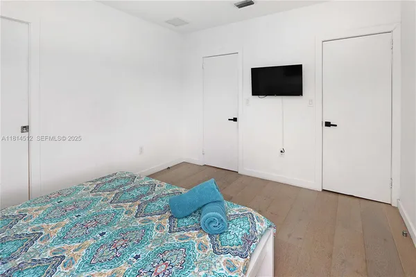 a bedroom with a bed and a flat screen tv