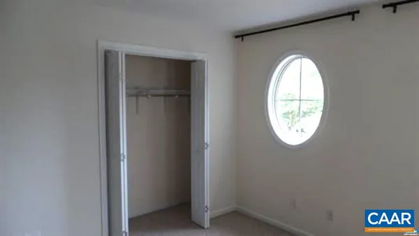 an empty room with window and mirror