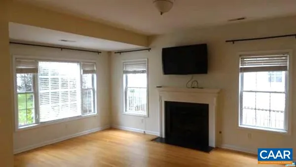 a view of an empty room with a fireplace and a window