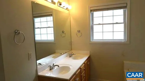 a bathroom with a sink mirror and a window