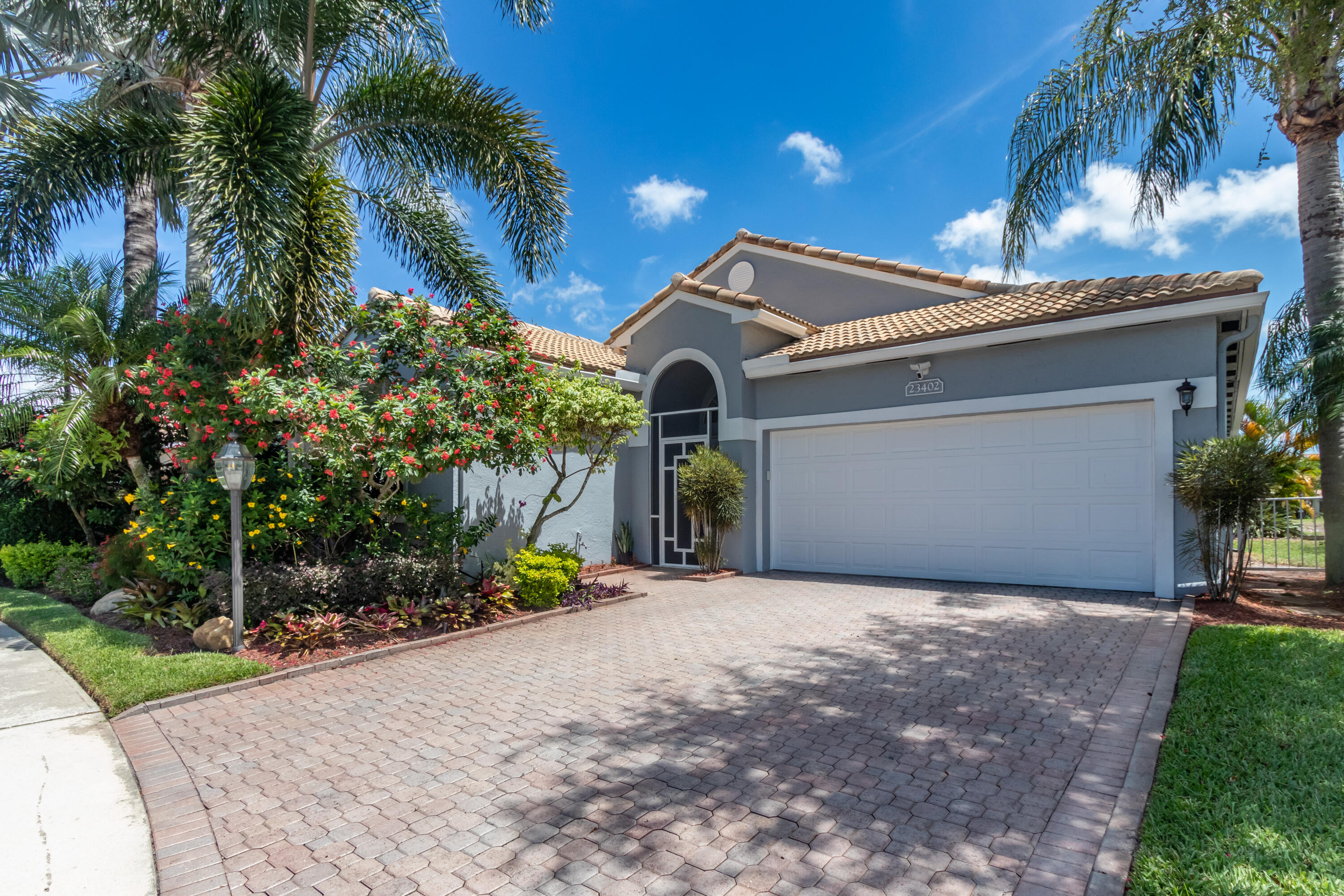 23402 Torre Circle Boca Raton, FL 33433 - Photo 1 of 44 a front view of a house with a yard and a garage