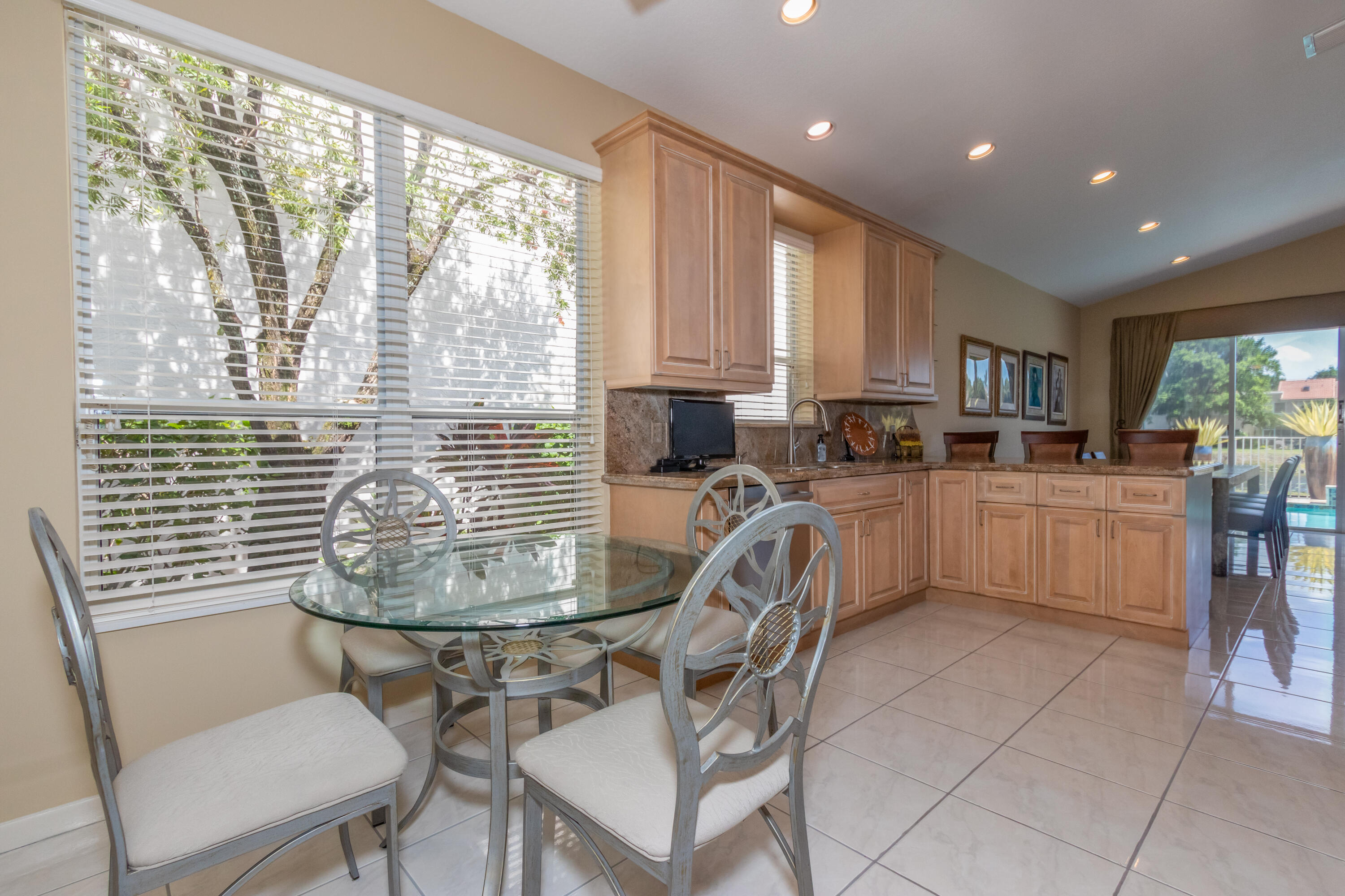 23402 Torre Circle Boca Raton, FL 33433 - Photo 12 of 44 a kitchen with a table chairs sink microwave and cabinets