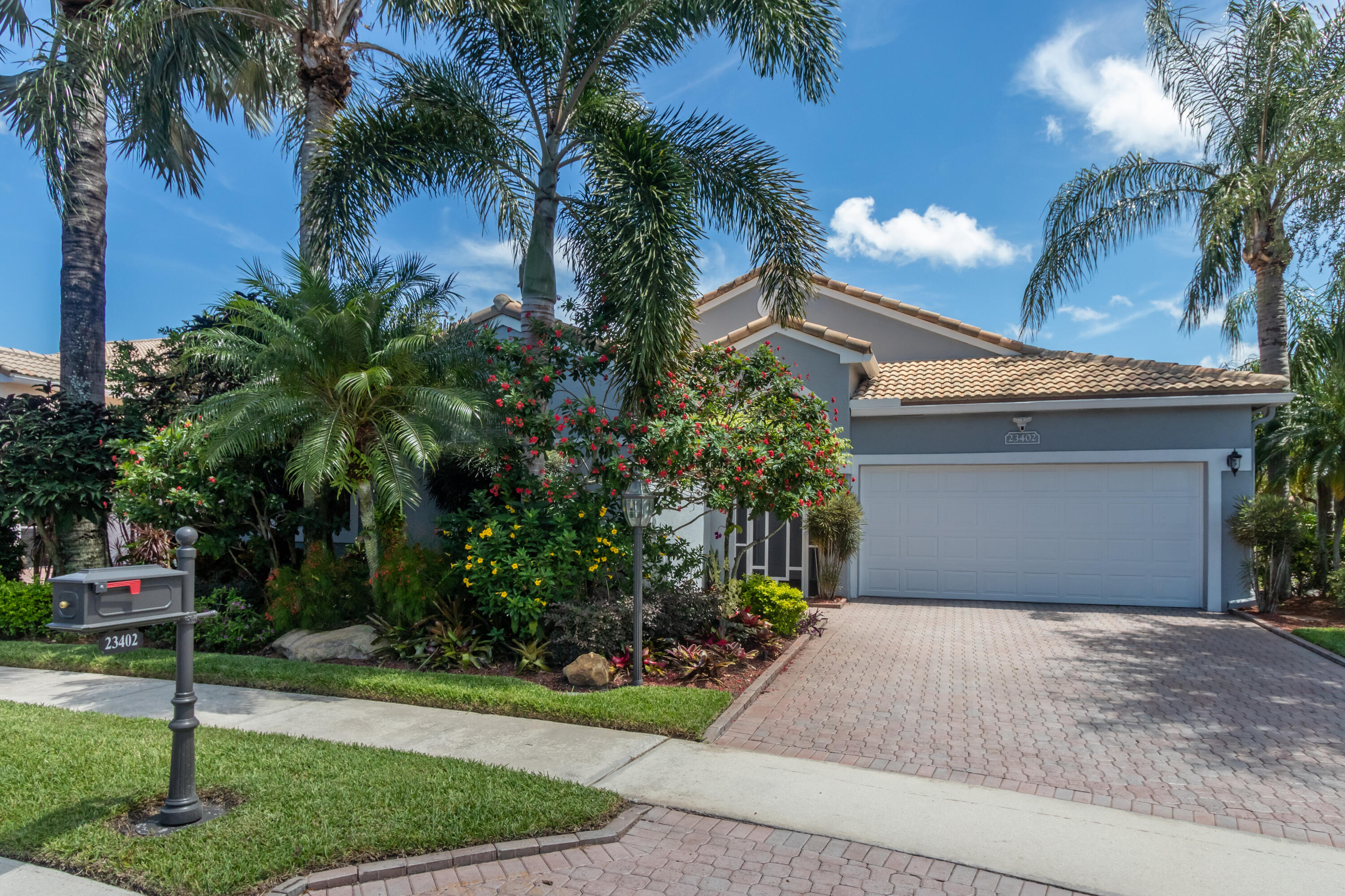 23402 Torre Circle Boca Raton, FL 33433 - Photo 2 of 44 a front view of a house with a yard and palm trees
