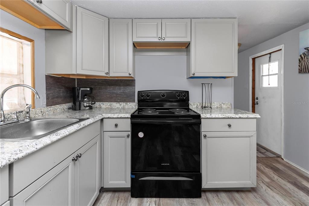 3003 Northeast 165th Lane Citra, FL 32113 - Photo 13 of 40 a kitchen with a sink stove and cabinets