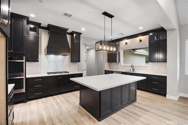 a large kitchen with kitchen island a sink stainless steel appliances and cabinets