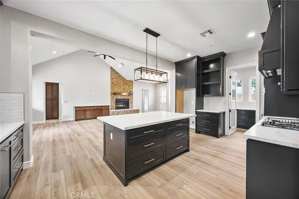 a kitchen with stainless steel appliances granite countertop a sink a stove and a wooden floors