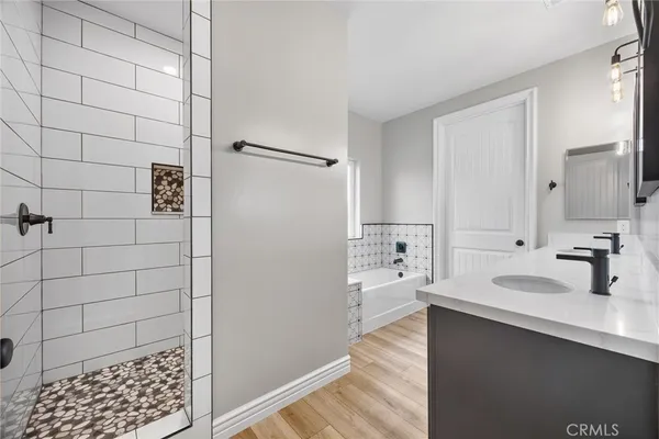 a bathroom with a tub sink and mirror