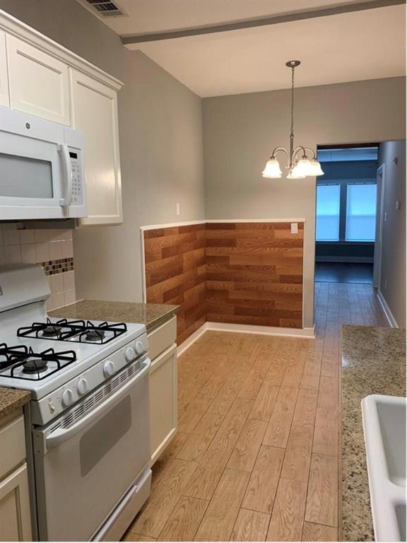 200 East 12th Street Dallas, TX 75203 - Photo 1 of 14 a kitchen with granite countertop a stove a sink and a refrigerator