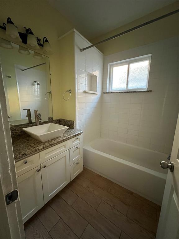 200 East 12th Street Dallas, TX 75203 - Photo 11 of 14 a bathroom with a granite countertop sink a toilet and bathtub