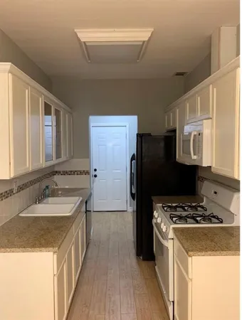 a kitchen with a sink a refrigerator and a stove