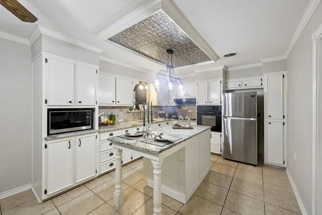 a kitchen with a sink a refrigerator and a stove top oven