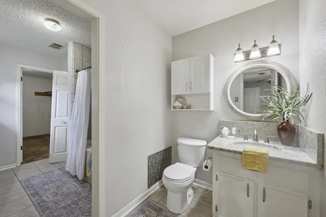 a bathroom with a toilet sink vanity and mirror