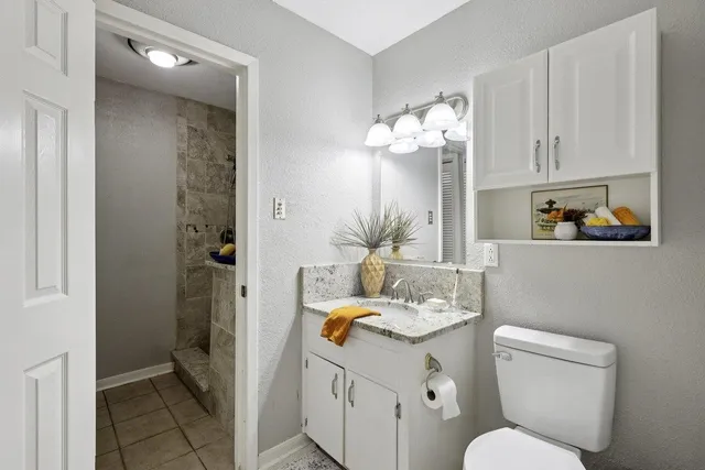 a bathroom with a sink vanity granite and toilet