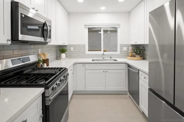 a kitchen with stainless steel appliances a stove microwave and sink