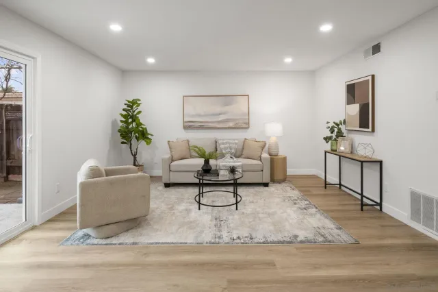 a living room with furniture and a painting on the wall