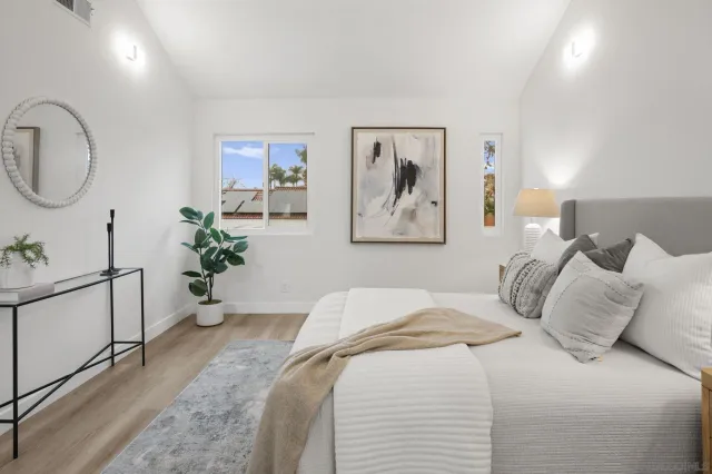 a bedroom with a large bed and a potted plant
