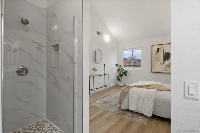 a bedroom with a bed and a painting on the wall