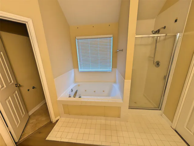 a bathroom with a tub a sink a window and a shower