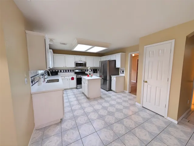 a kitchen with stainless steel appliances a refrigerator sink and cabinets