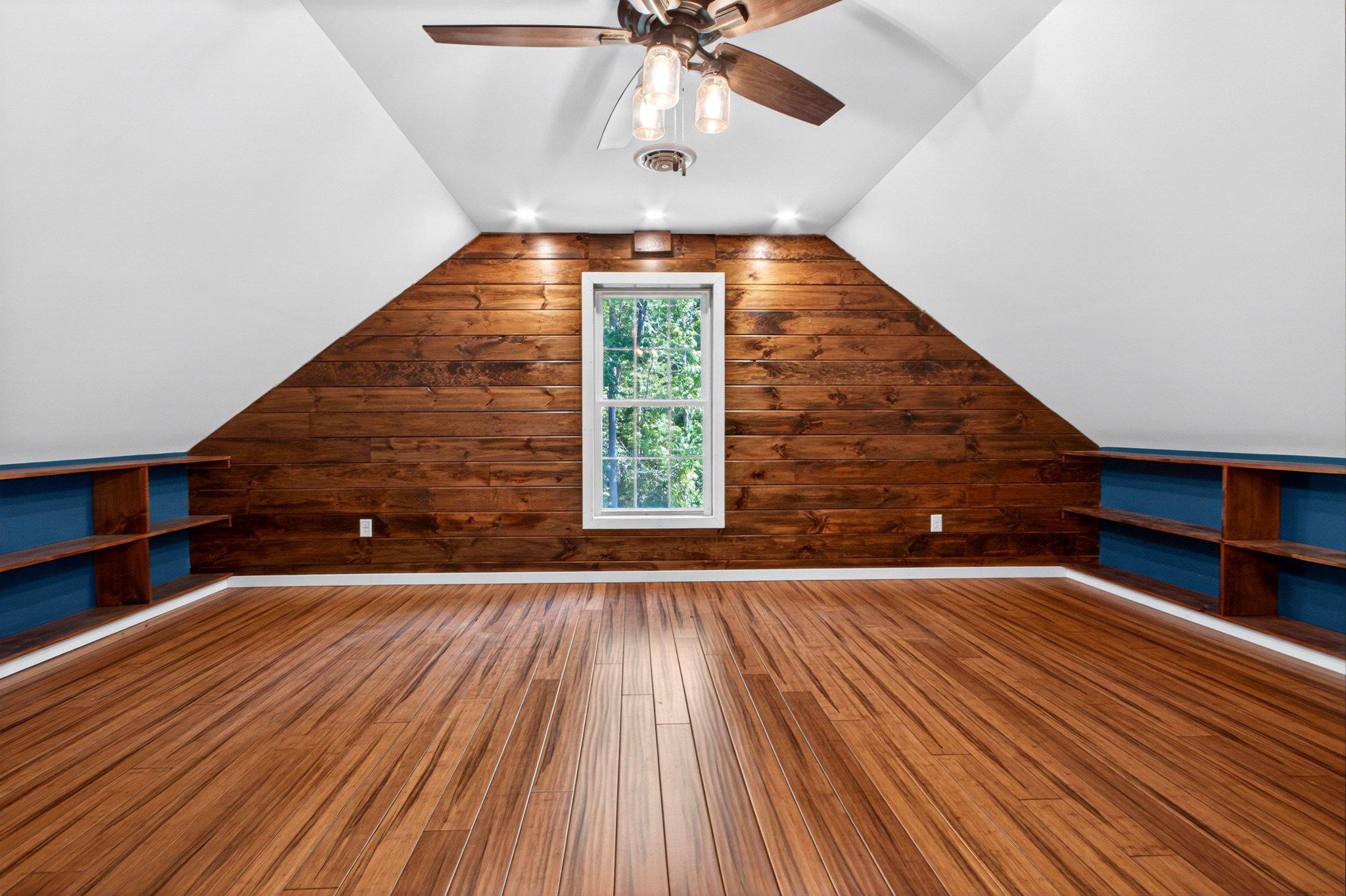 10878 Memory Road Harrington, DE 19952 - Photo 50 of 94 a view of an empty room with wooden floor ceiling fan and windows