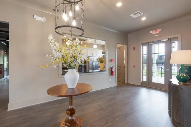 a dining room with wooden floor a chandelier a glass table and chairs