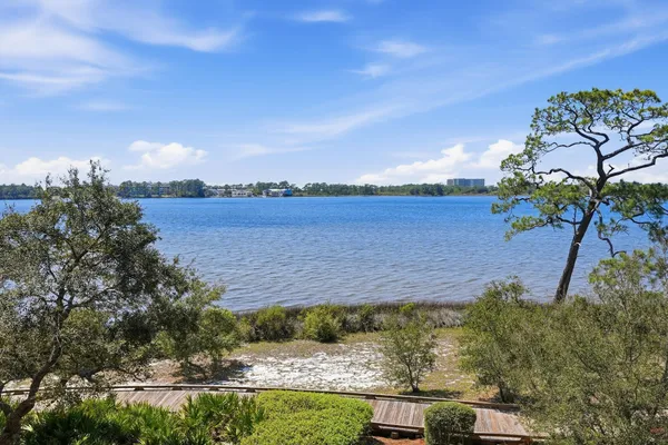 a front view of a house with yard and lake view
