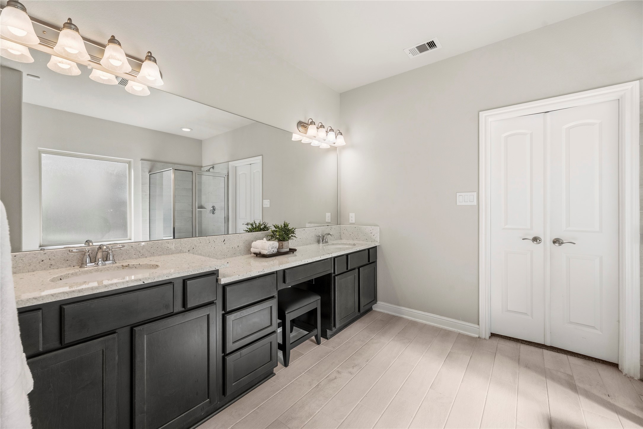 3319 Learning Tree Lane Rosenberg, TX 77471 - Photo 15 of 44 One seemingly endless mirror runs the length of the quartz countertops in the primary en suite. In addition to must-have dual sinks, a built-in makeup vanity provides a posh pampering space for morning time routines or nighttime rituals.