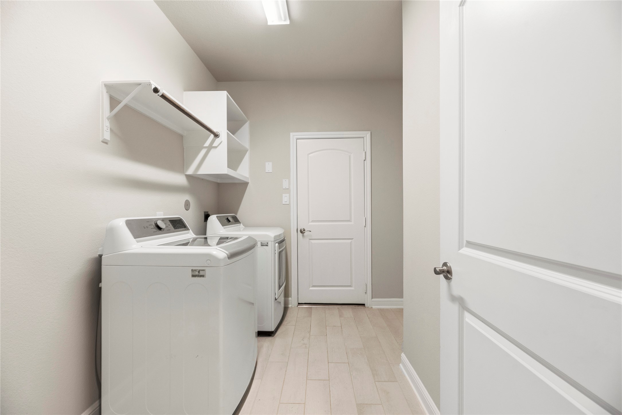 3319 Learning Tree Lane Rosenberg, TX 77471 - Photo 23 of 44 Laundry time is made efficient and quick with this dedicated space. Store laundry essentials on the above shelving and hang delicate pieces of clothing on the bars.